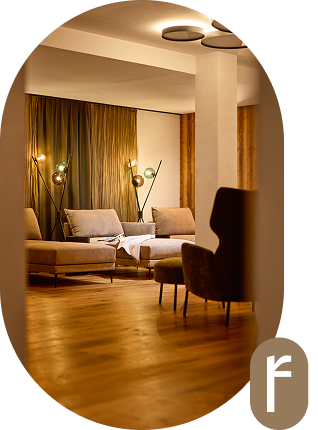 Stilvolles Wohnzimmer mit modernen Stühlen, warmer Beleuchtung und Holzboden.