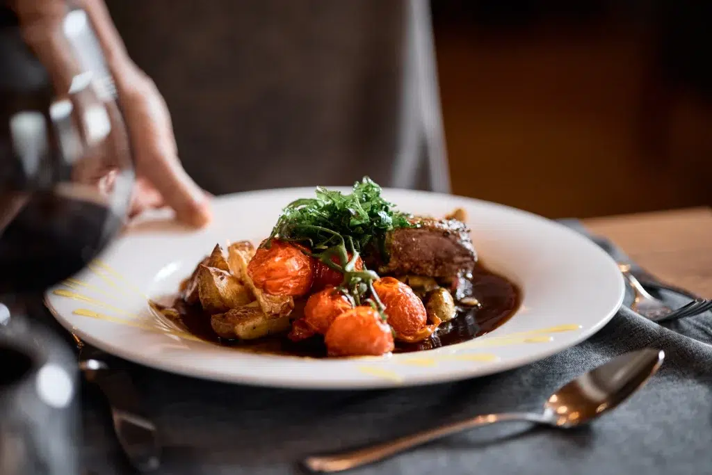Gebratener Fleischteller mit Kartoffeln und Grünzeug, wie er im Hotel Kaunertal serviert wird.