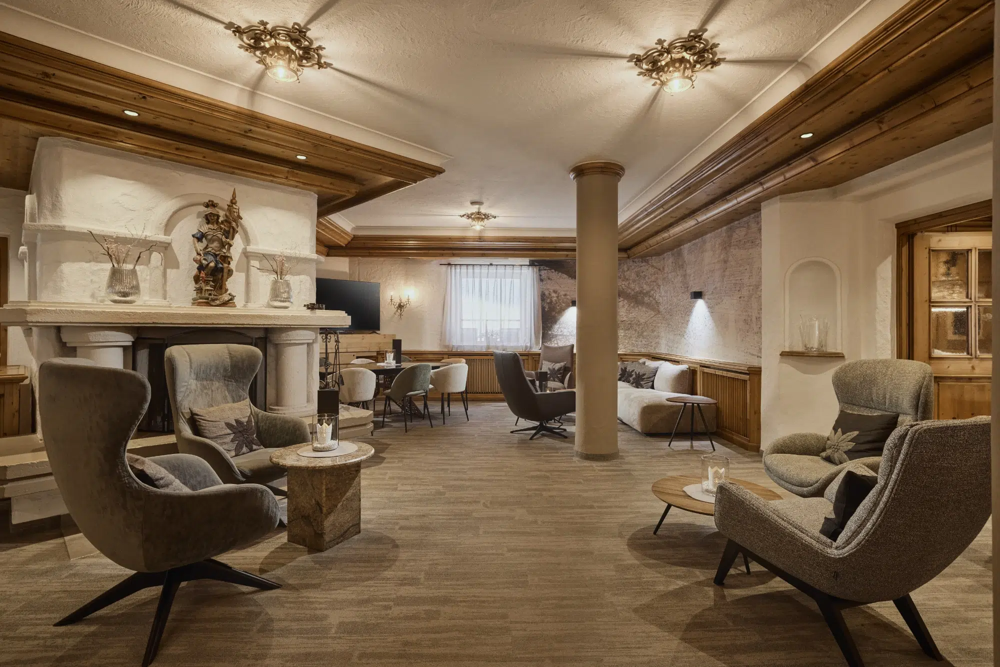 Gemütliche Lounge mit modernen Sesseln, Holzakzenten, einem dekorativen Kamin und einer Bildergalerie.